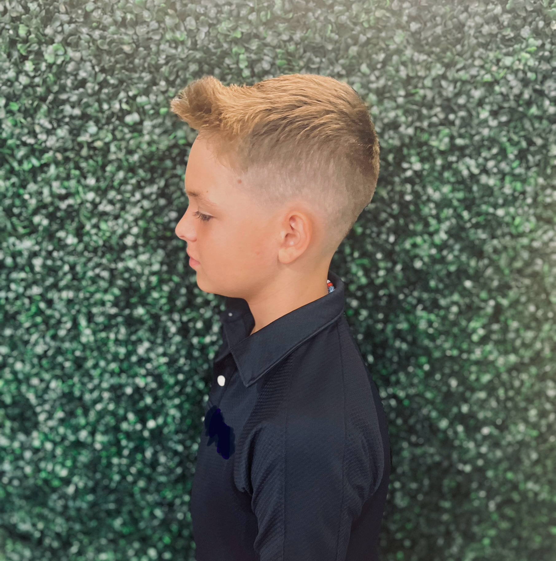A boy's fade haircut seen from the side